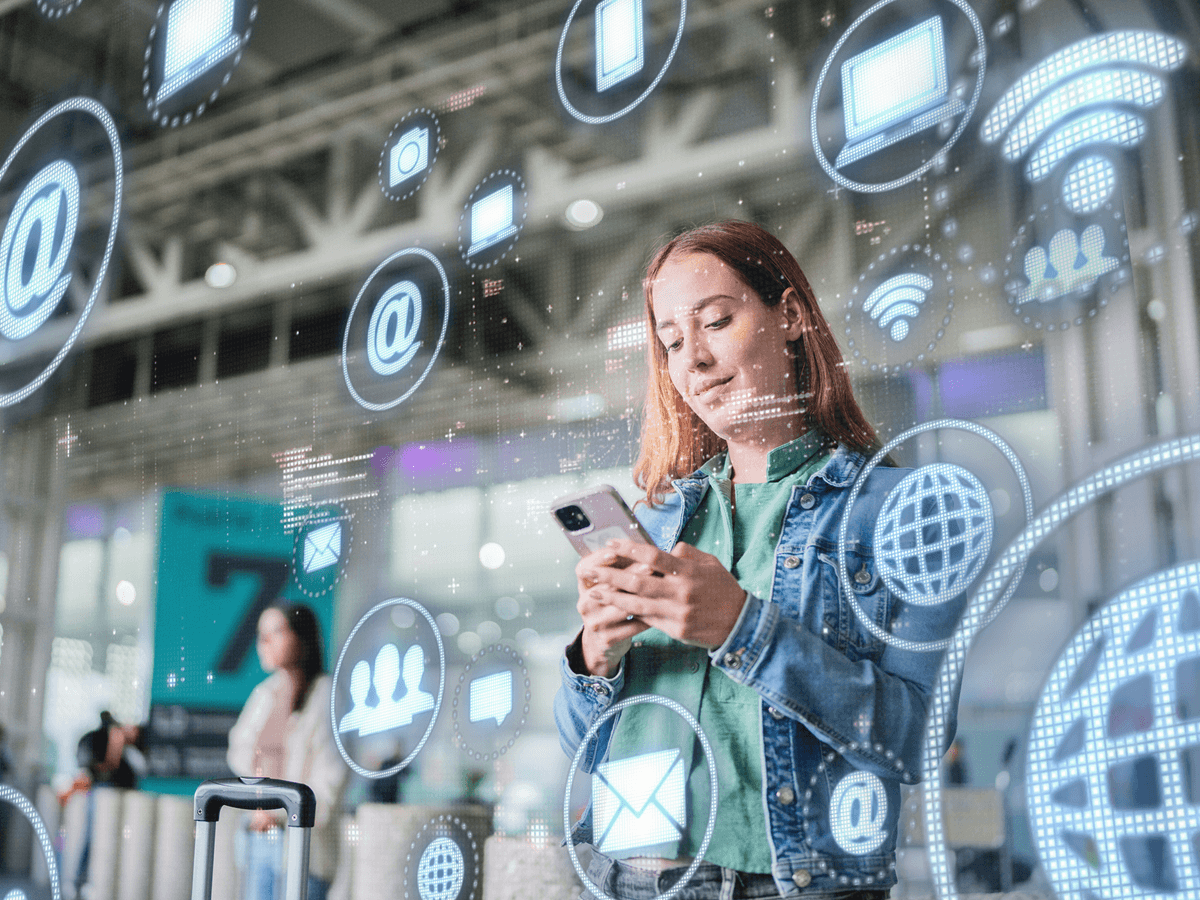 Woman using smartphone with digital icons overlay